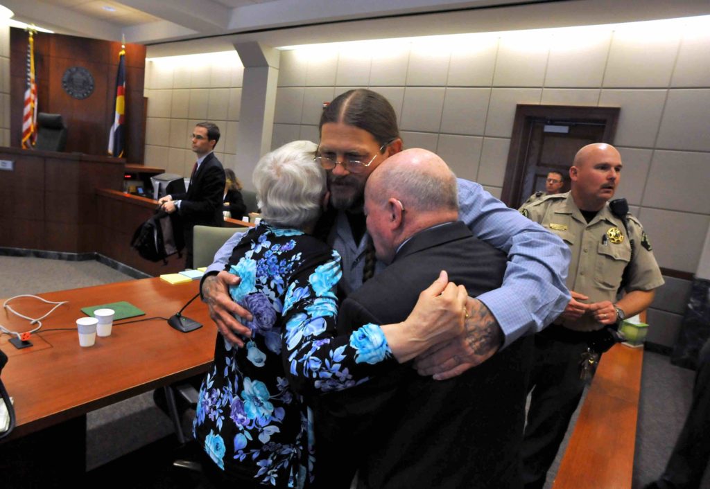 Robert Dewey embraces his parents after being exonerated from a murder conviction in Grand Junction Colo.