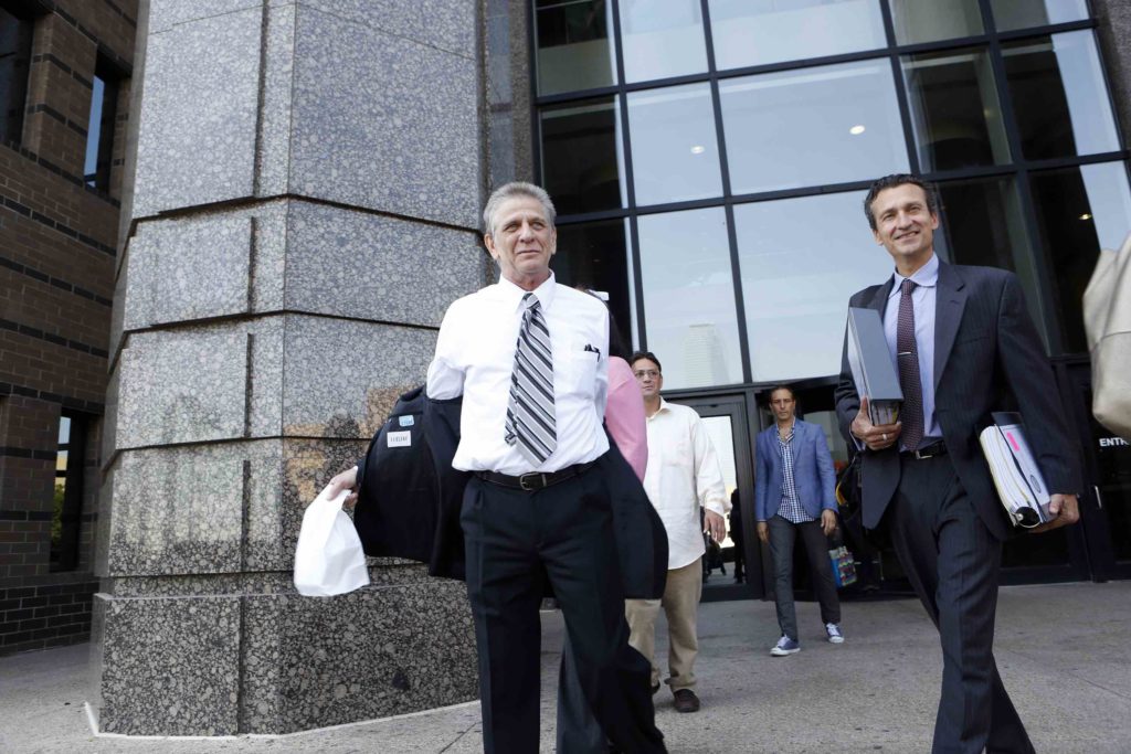 Steven Mark Chaney takes off his jacket while walking out of the Dallas courthouse this afternoon after a court reversed his 1987 murder conviction because of discredited bite mark testimony.  Innocence Project Attorney M. Chris Fabricant is on the right. Photographed on Monday, October 12, 2015. (Photo copyright Lara Solt)